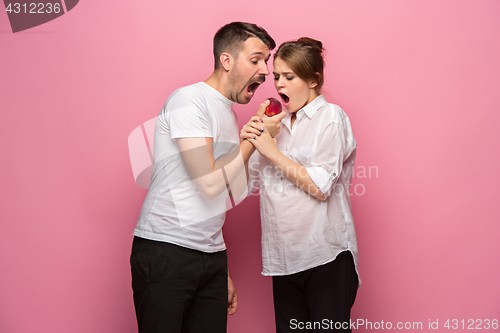 Image of The funny surprised handsome man and his beautiful pregnant wife