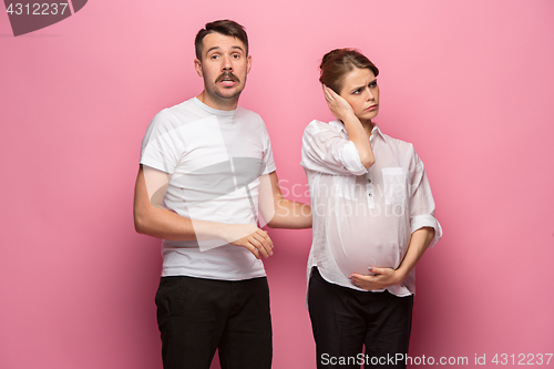 Image of The funny surprised handsome man and his beautiful pregnant wife\'s tummy