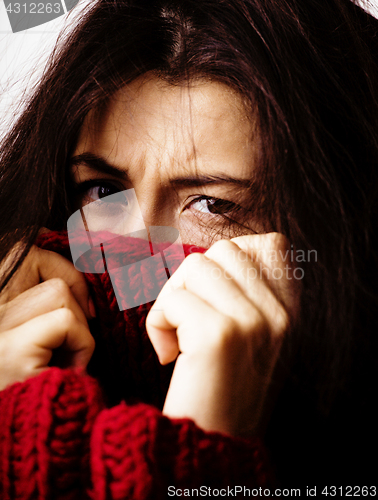 Image of young brunette gloomy woman in sweater all over her face, messed hair