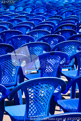 Image of Bright plastic chairs standing in a row.