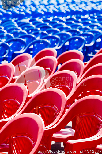 Image of Bright plastic chairs standing in a row.