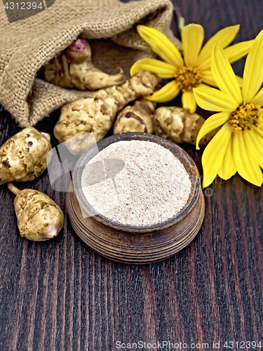 Image of Flour of Jerusalem artichoke in clay bowl with flower on board