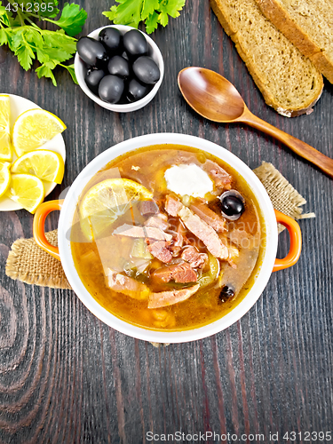 Image of Solyanka with lemon in bowl on board top