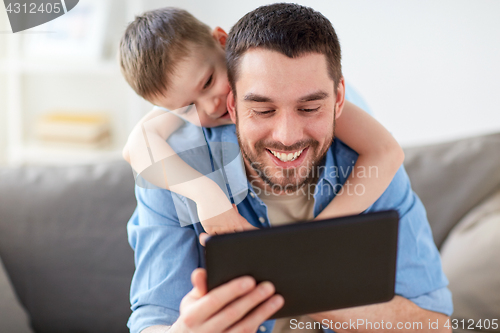 Image of father and son with tablet pc playing at home