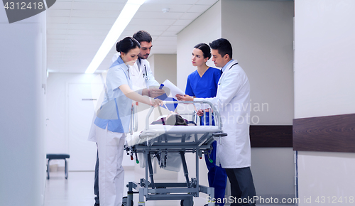 Image of medics with woman on hospital gurney at emergency