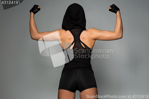 Image of young woman posing and showing muscles