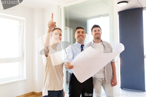 Image of realtor showing blueprint of new home to couple