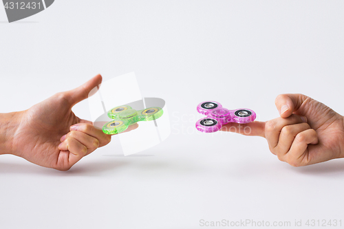 Image of close up of two hands playing with fidget spinners