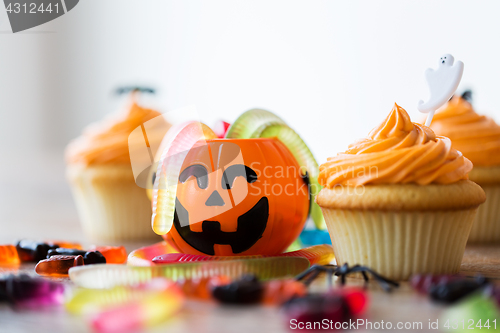 Image of halloween party decorated cupcakes on wooden table