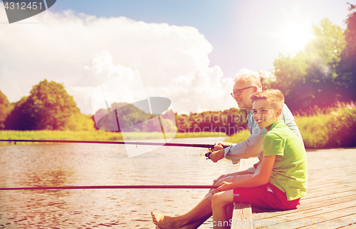 Image of grandfather and grandson fishing on river berth