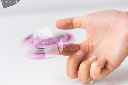 Image of close up of hand playing with fidget spinner