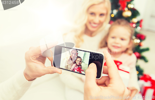 Image of man taking picture of his family by smatrphone