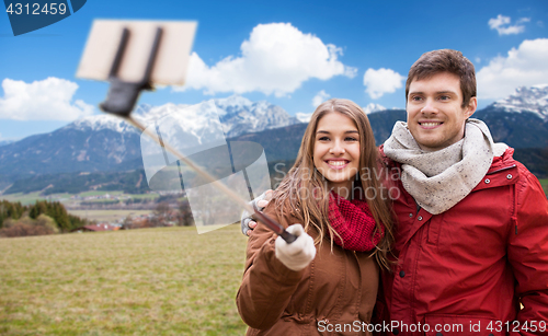 Image of couple taking selfie by smartphone over alps 
