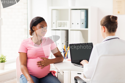 Image of doctor with laptop and pregnant woman at clinic