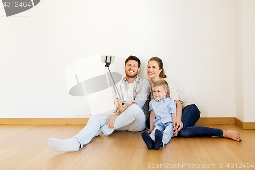Image of family taking selfie by smartphone at new home
