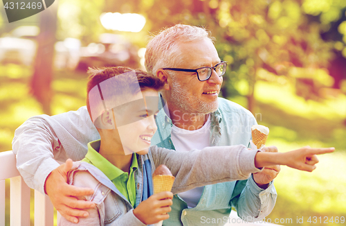 Image of old man and boy eating ice cream at summer park