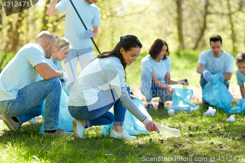 Image of volunteers with garbage bags cleaning park area