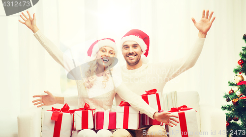 Image of happy couple at home with christmas gift boxes