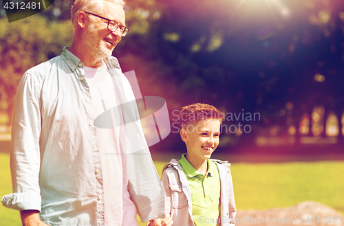 Image of grandfather and grandson walking at summer park