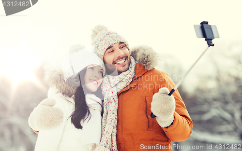 Image of happy couple taking selfie by smartphone in winter