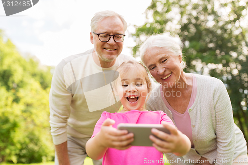 Image of senior grandparents and granddaughter selfie