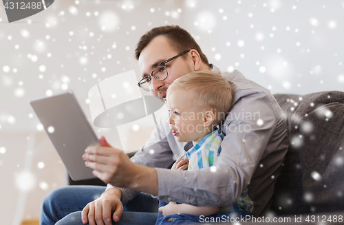 Image of father and son with tablet pc playing at home