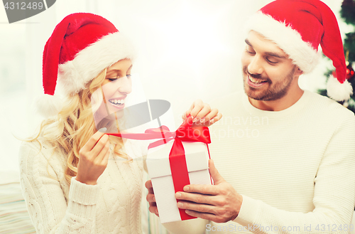 Image of happy couple at home with christmas gift box