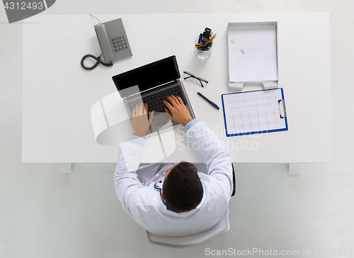 Image of doctor with cardiogram and laptop at clinic