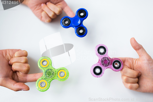 Image of close up of hands playing with fidget spinners