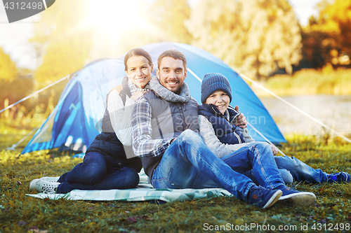 Image of happy family with tent at camp site