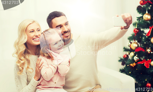 Image of family taking selfie with smartphone at christmas