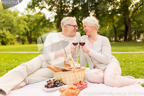 Image of happy senior couple having picnic at summer park