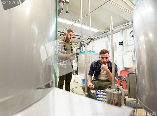 Image of men with tablet pc at craft beer brewery filter