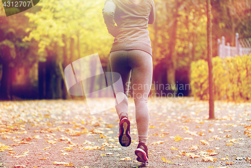 Image of close up of young woman running in autumn park