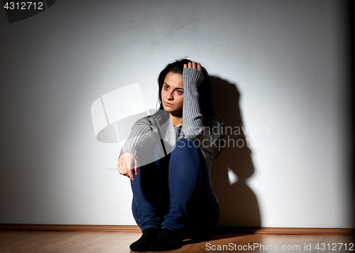 Image of unhappy woman crying on floor at home