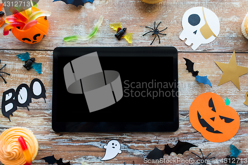 Image of tablet pc, halloween party decorations and treats