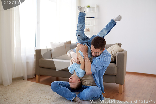 Image of father with son playing and having fun at home