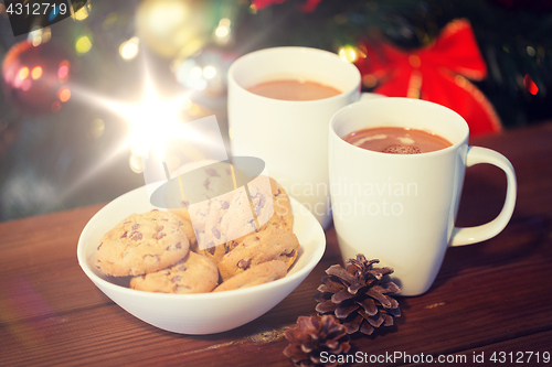 Image of oat cookies and hot chocolate over christmas tree