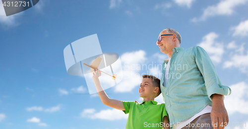 Image of senior man and boy with toy airplane over sky