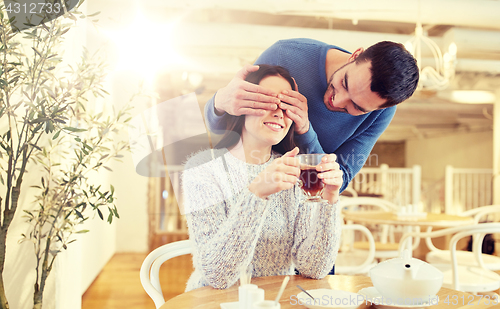 Image of happy couple drinking tea at cafe