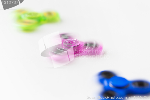 Image of three spinning fidget spinners on white background