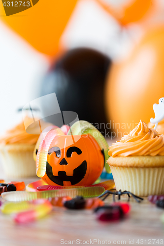 Image of halloween party decorated cupcakes on wooden table