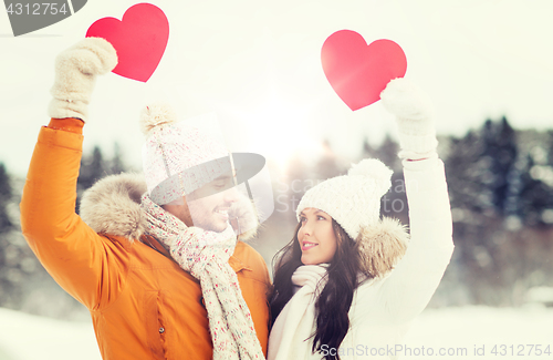 Image of happy couple with red hearts over winter landscape