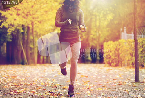 Image of close up of young woman running in autumn park