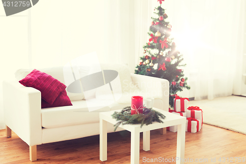Image of sofa, table and christmas tree with gifts at home