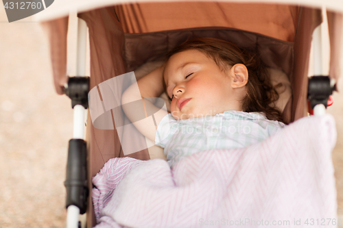 Image of little child or baby sleeping in stroller outdoors