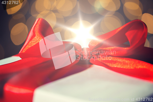 Image of close up of christmas gift with bow over lights