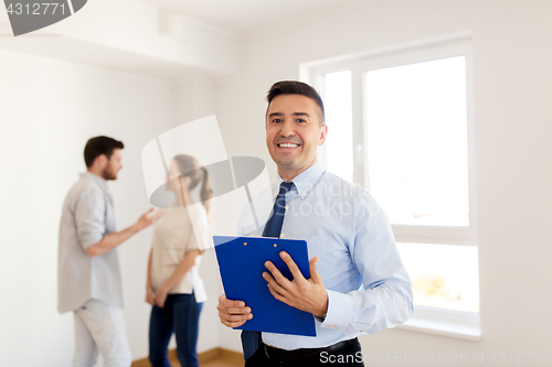 Image of realtor with clipboard and couple at new home