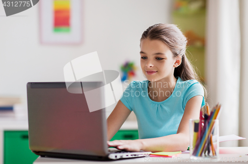 Image of girl typing on laptop at home