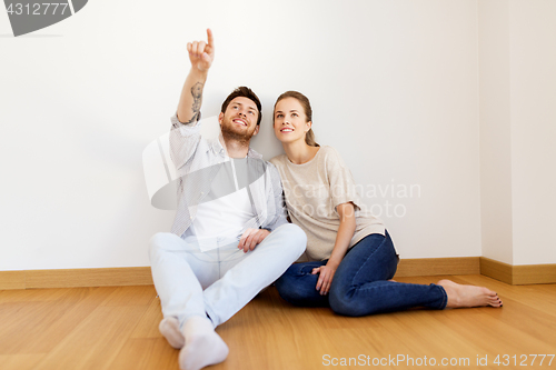 Image of happy couple at empty room of new home